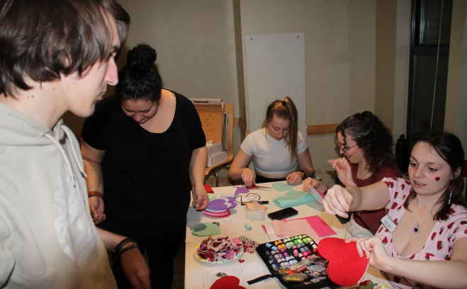 Students making heart crafts in lounge of resident hall