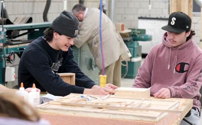 Two males students building and fabricating in an engineering class