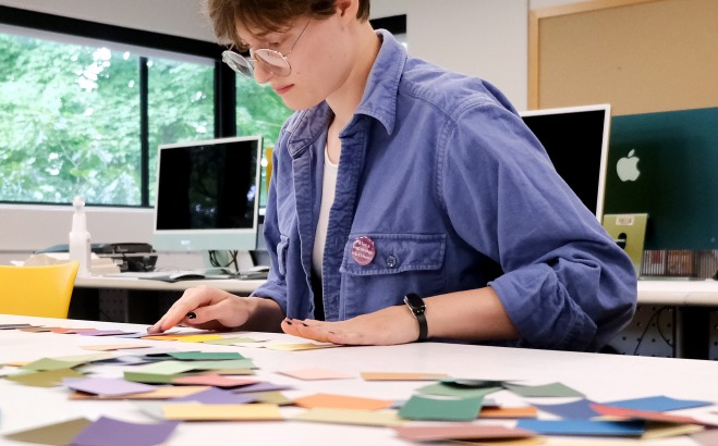 Student working at desk with color swatches in typography class