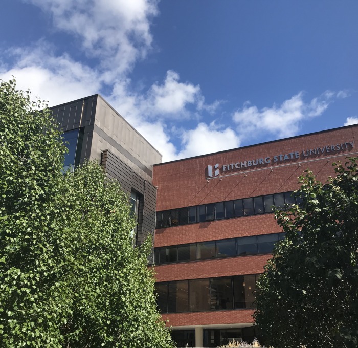 Exterior of Hammond building with trees and Fitchburg State logo on building