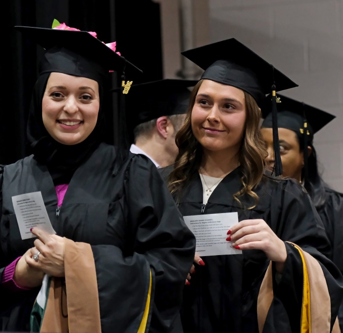 Graduate students lined up by stage at commencement