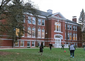 Students playing game in the grass in front of Percival Hall