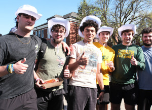 Football players with food on the quad in cowboy hats.
