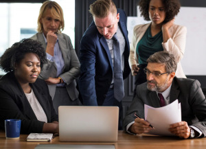 Office workers gathered around a laptop