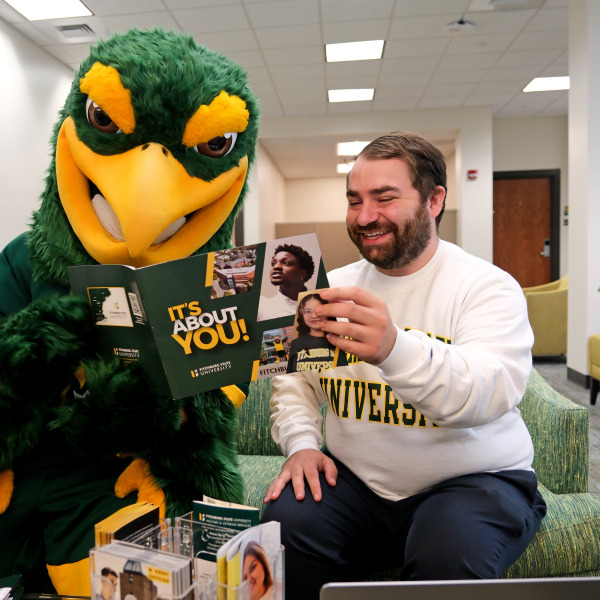 Freddy and Tyler looking at viewbook in welcome center/admissions
