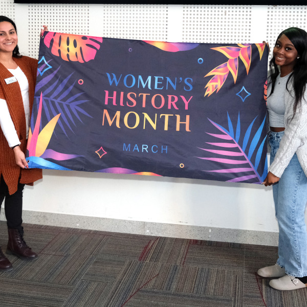 Krysta and student holding flag in Main Lounge.
