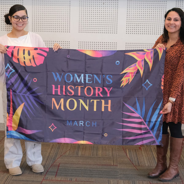Krysta and student holding flag in Main Lounge.