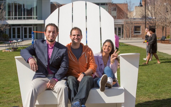 Students in a large chair on the quad 