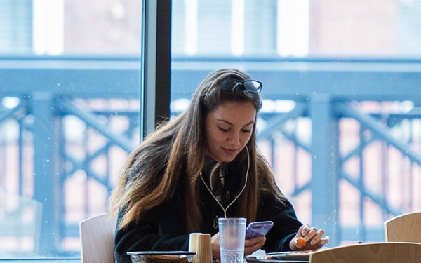Student on cell phone at a table