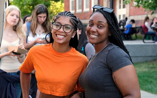 Happy smiling female students on the quad at Rock the Block