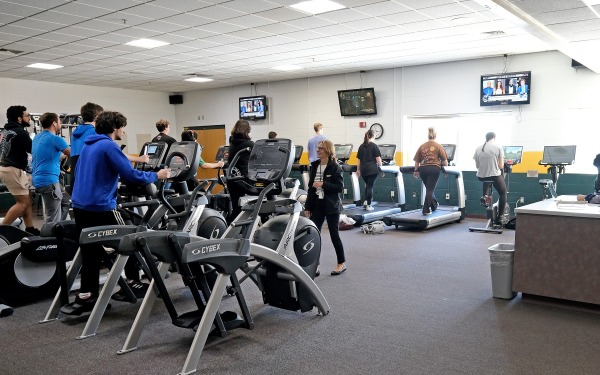 fitness center room with equipment and students