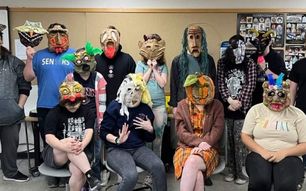 Students with masks on that they made in class