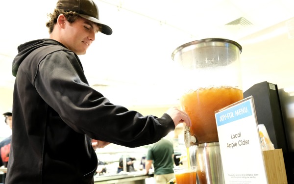 Male student getting cider in Holmes