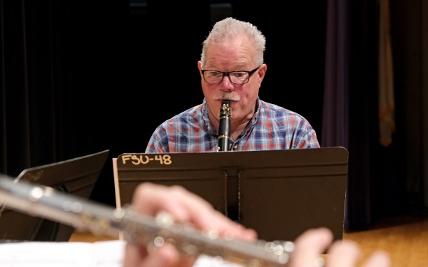 Male faculty playing clarinet and flute in foreground