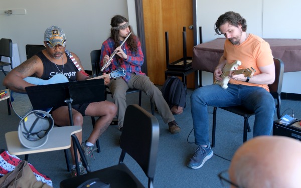Male students faculty rehearsing guitar and flute