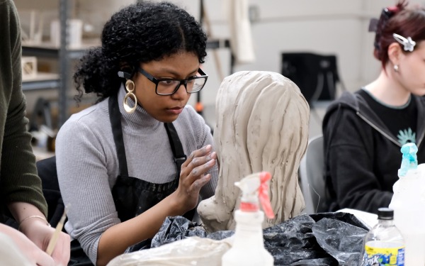 Student working on bust in Ceramics class