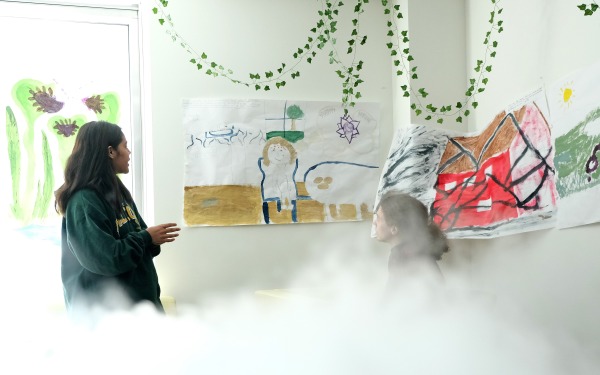 students with posters they painted on the walls