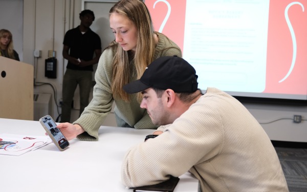 Alumnus Austin Soares ‘14 working with student in class