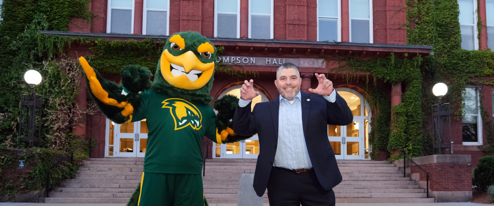 Alum Jason Polonsky goes Talons Up with mascot Freddy in front of Thompson Hall