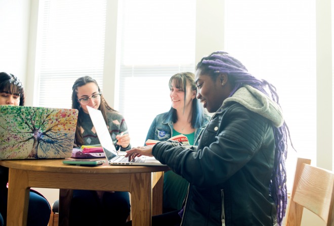 Group of students working together with laptops