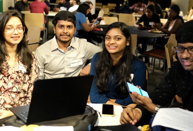 Group of international students male and female in Falcon Hub at table