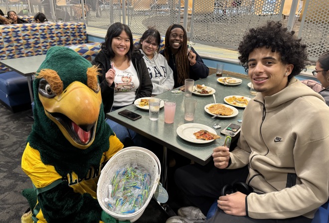 Students eating at a table and Freddy giving out candy