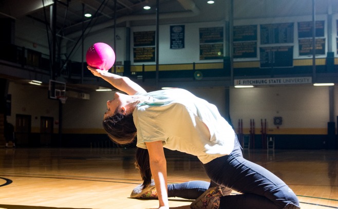 student stretches on the gym floor 