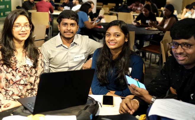 Group of international students male and female in Falcon Hub at table