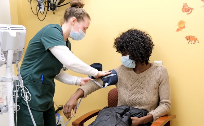 Nursing student taking blood pressure in sim lab