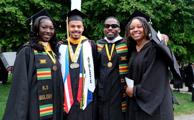 Group of smiling grads outside at undergrad commencement