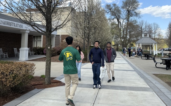 Tour guide and group walking on campus