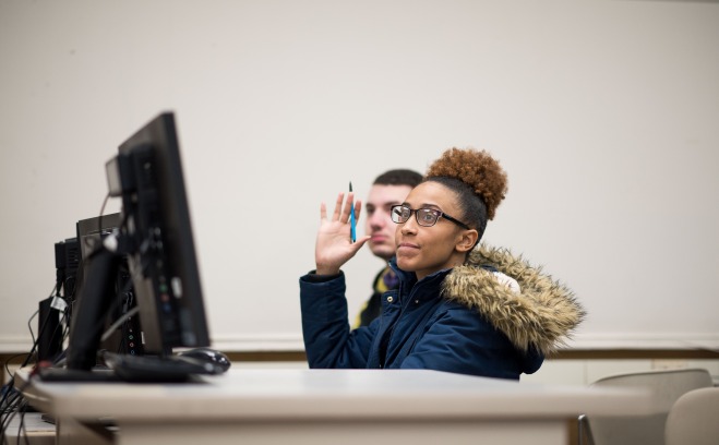 Student raises her hand in computer science class