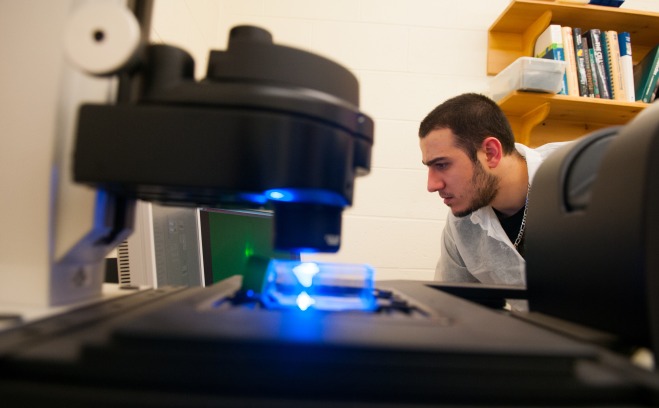 student with microscope