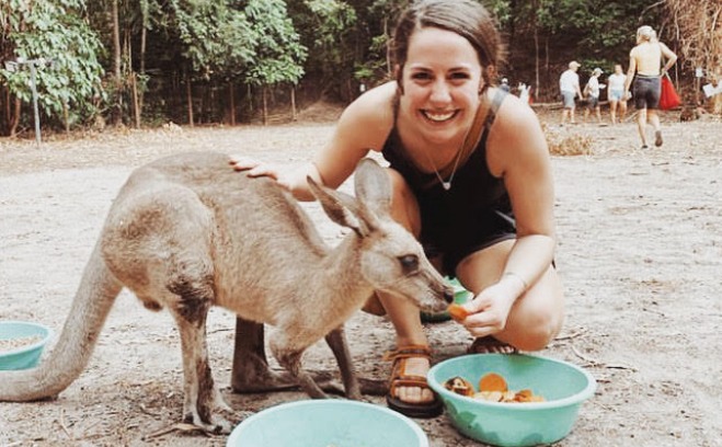 Student overseas poses with animal