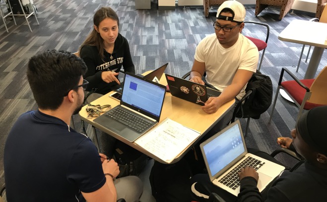 Group of students working together with laptops