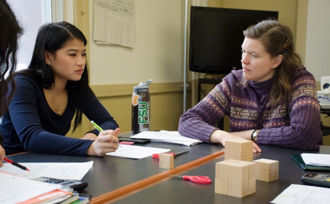 Teacher with student discussing math assignment