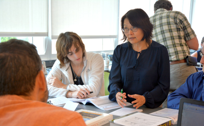 Students working with professor in a classroom