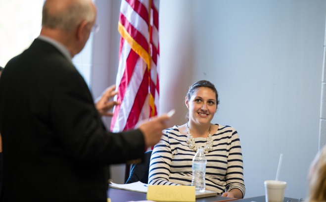 Student in classroom listening to teacher in front of flag