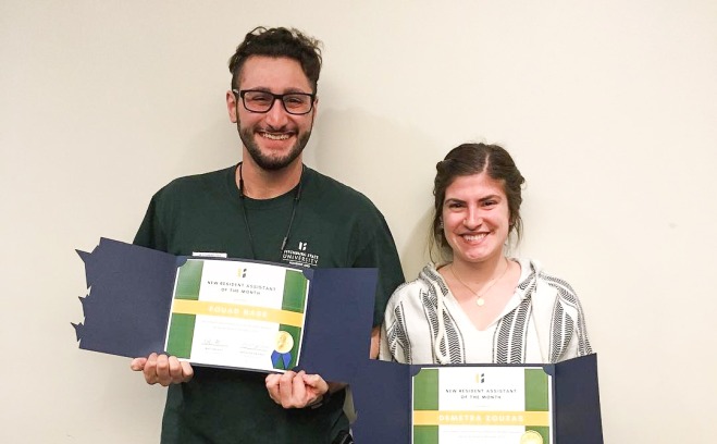 Male and female housing award recipients holding their certificates