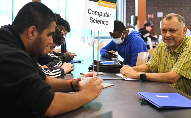 Computer Science student and teacher at orientation at table