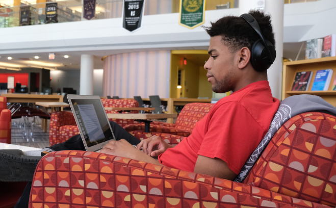 Student using laptop in campus library