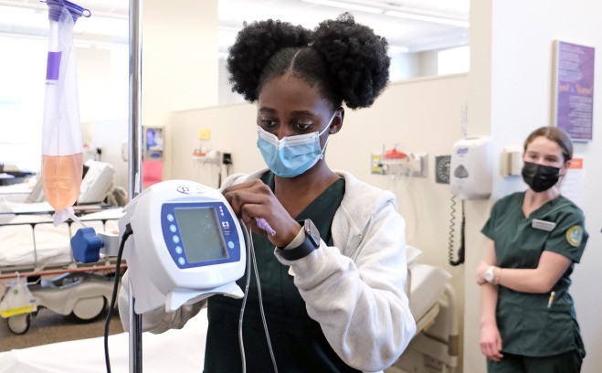 Nursing student in the lab hanging a bag of fluids