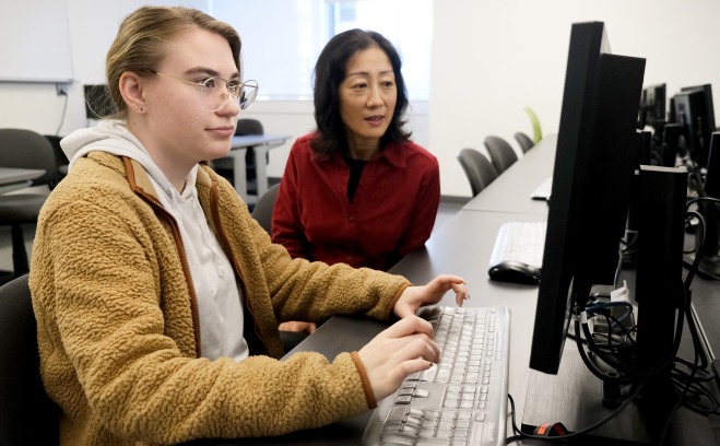 Female teacher and student at computer in classroom