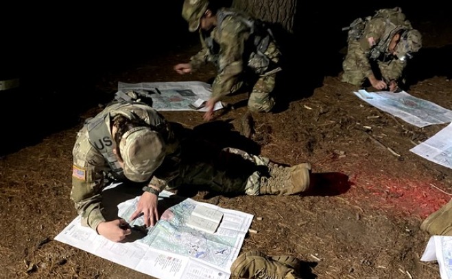 ROTC recruits in woods at night doing land navigation