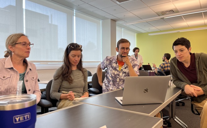 AP Institute students in a classroom looking at a laptop