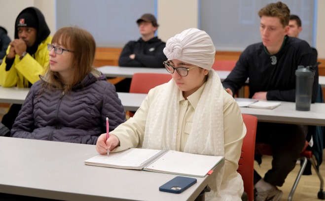 Students listening and taking notes in business management class