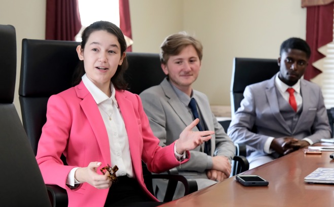 BSAD students discussing economy at conference table 