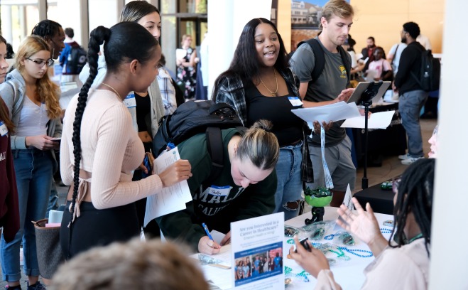 Internship fair students talking to employer and signing up