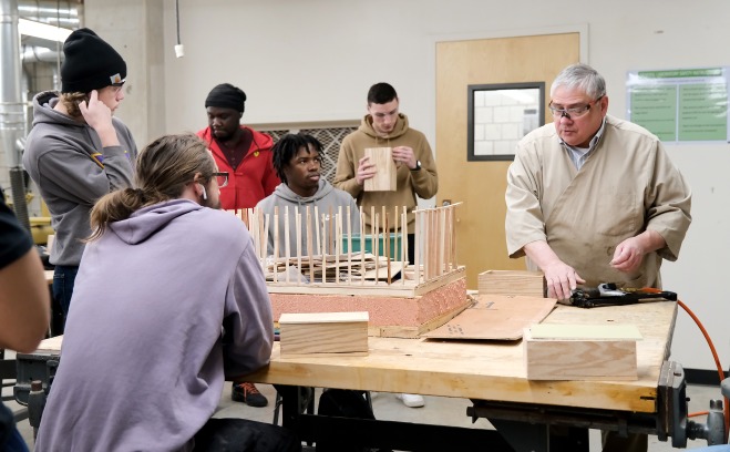 Wayne Whitfield and students building a model in classroom