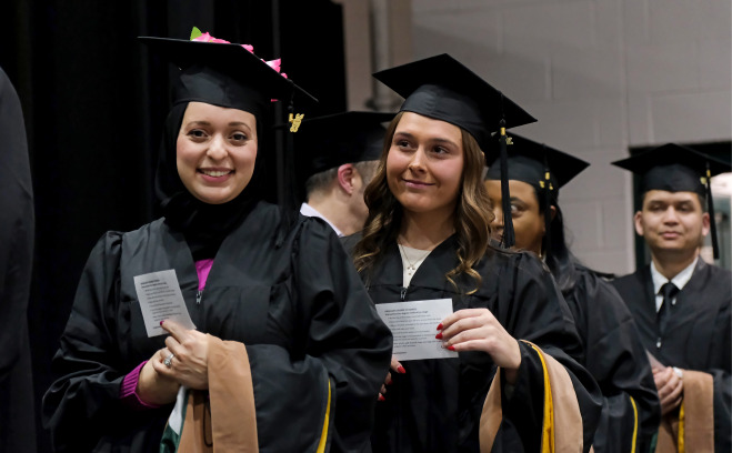 Graduate students lined up by stage at commencement